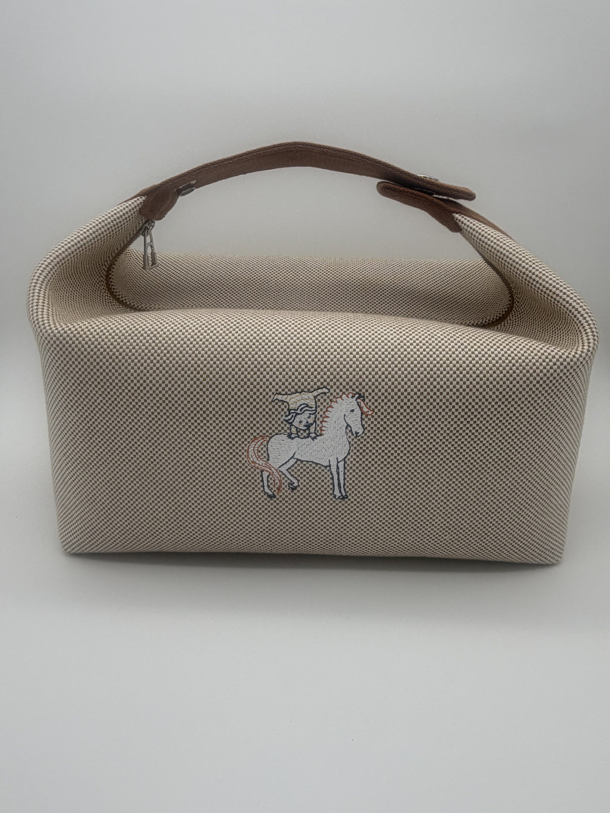 Front view of the Hermès Bride-A-Brac GM in beige and brown toile canvas with the embroidered horse motif