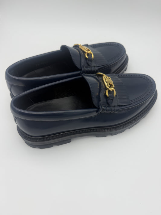 Three-quarter view of both navy Celine Margaret loafers showing the Triomphe chain and lug sole
