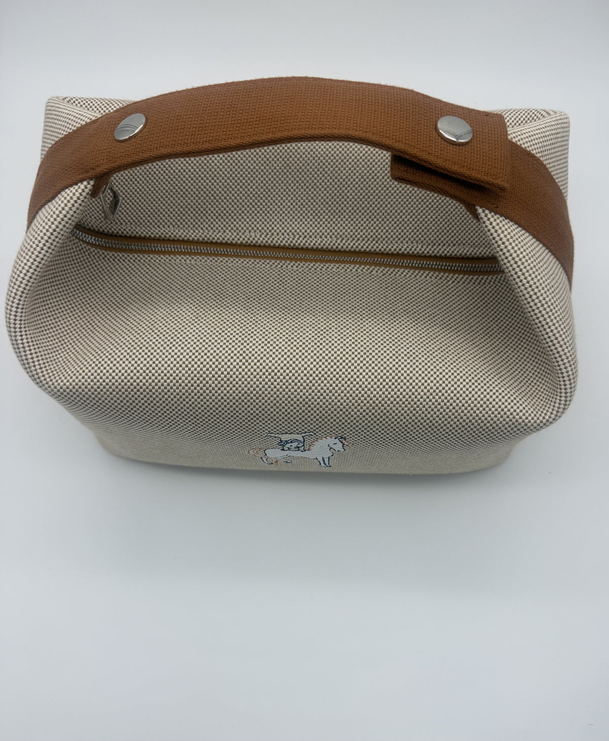 Top view showing the tan leather carry strap fastened on its silver snap studs