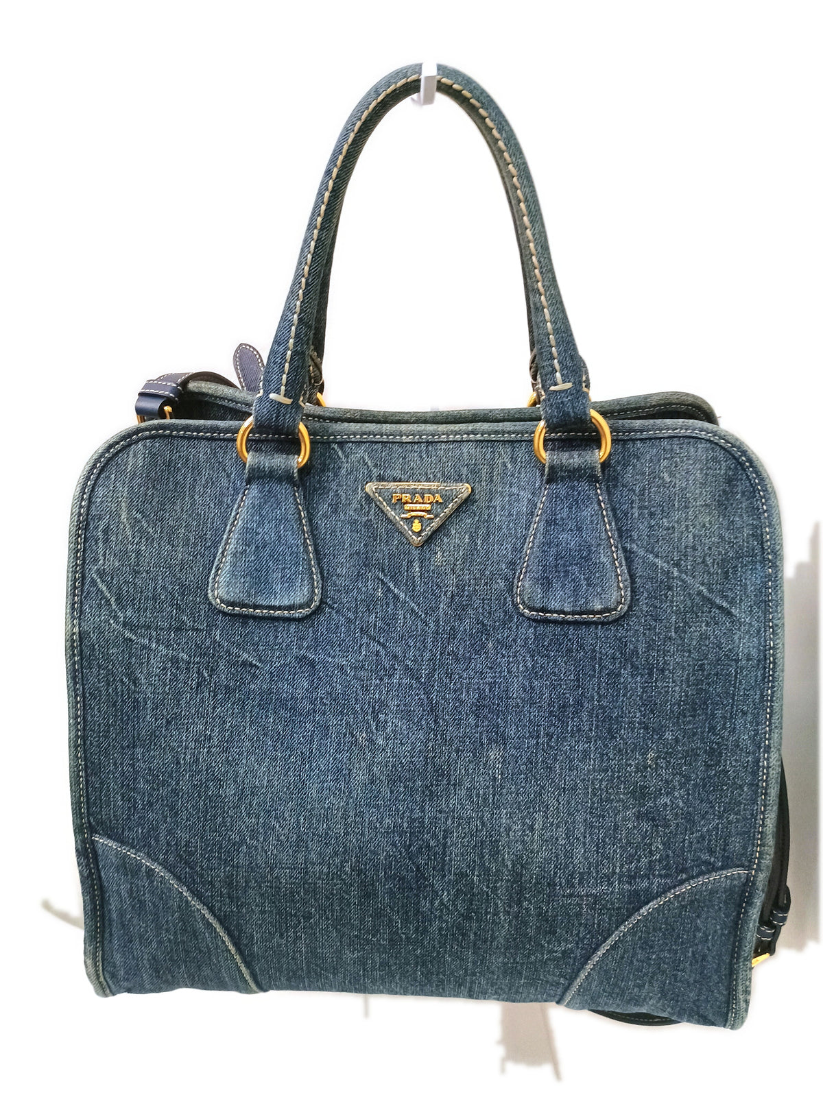 The bag on a stand, showing the structured shape and the detachable strap attachment