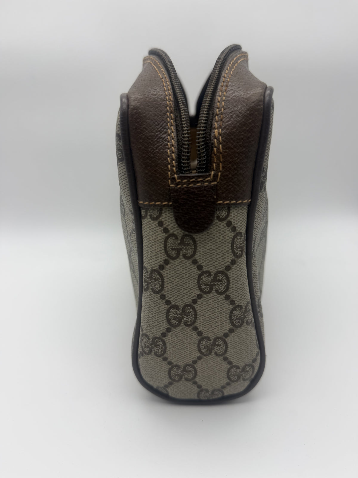 Side profile showing the gusset, the leather-trimmed zip and the piped edges