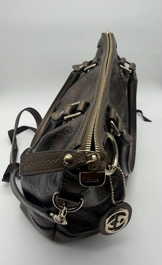 Gucci Sukey in metallic bronze Guccissima calfskin, side view showing the zip closure, light gold hardware and interlocking GG charm