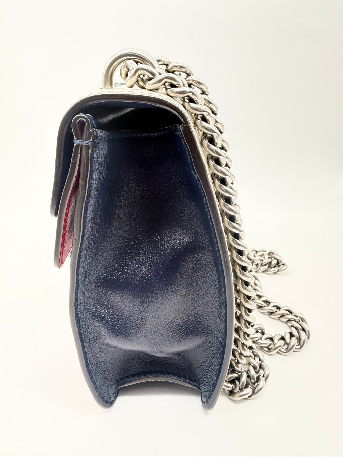 Side profile showing the navy gusset and the chain attachment