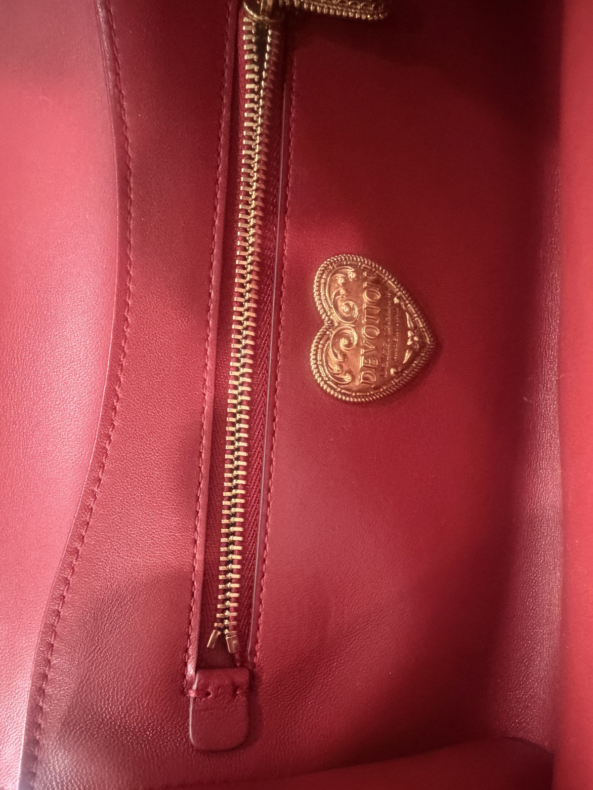 Interior detail with the gold DEVOTION heart plaque and zip pocket