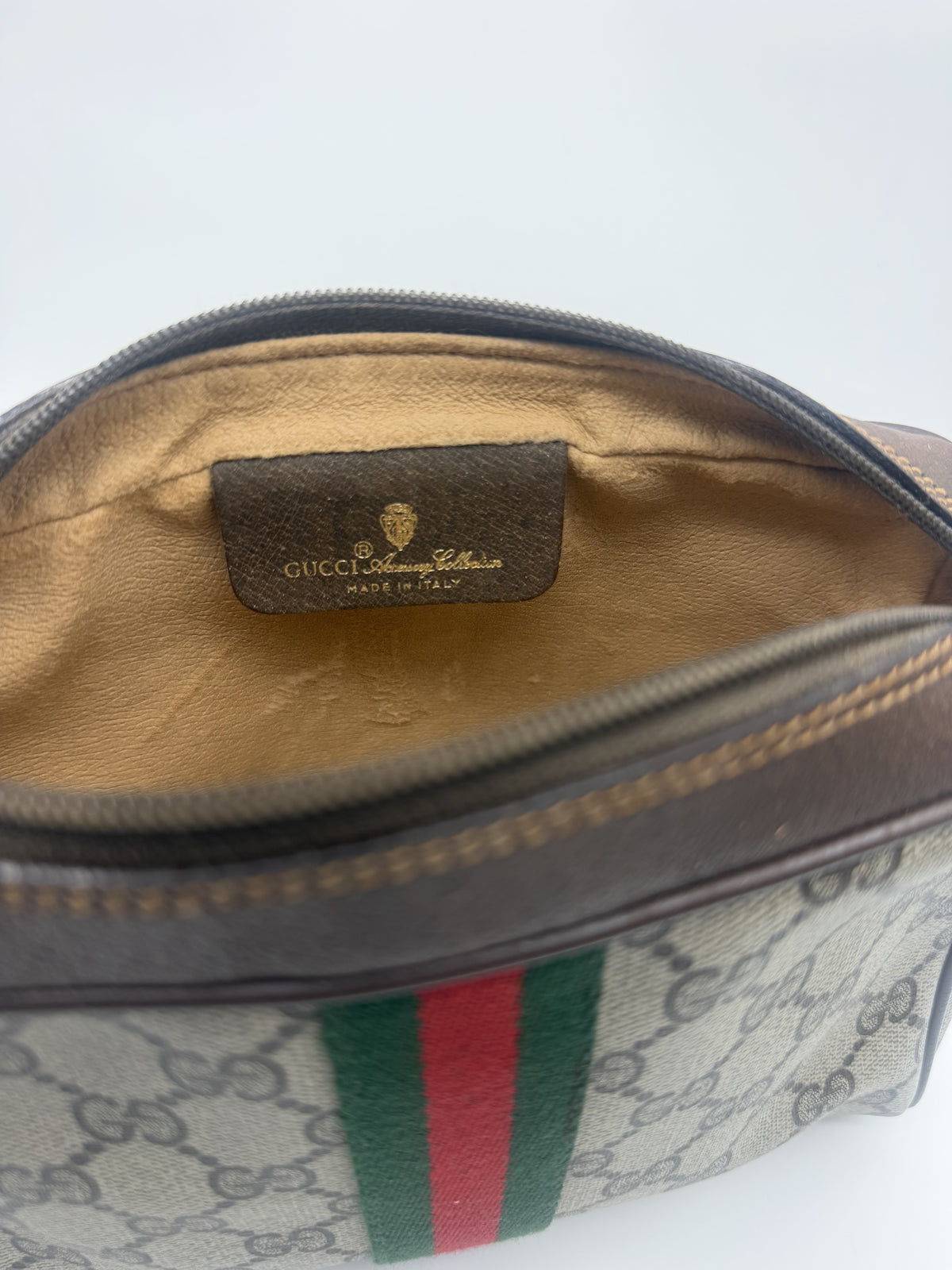Interior of the pouch with the tan lining and the GUCCI Accessory Collection tag stamped Made in Italy