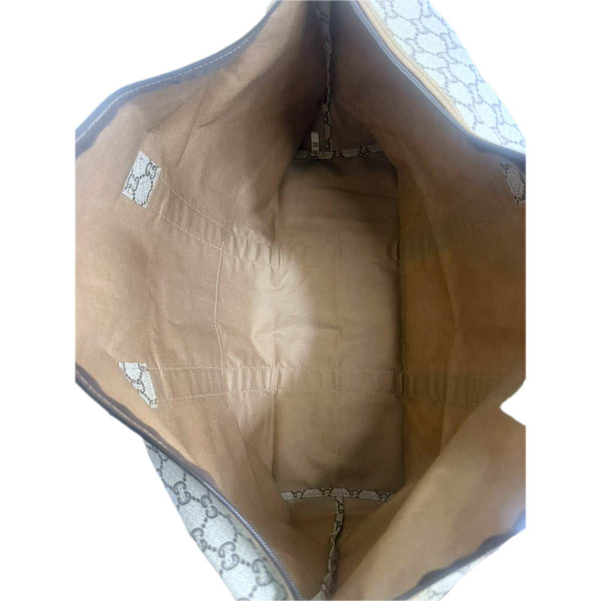 Interior of the tote showing the tan fabric lining and GG Plus canvas trim