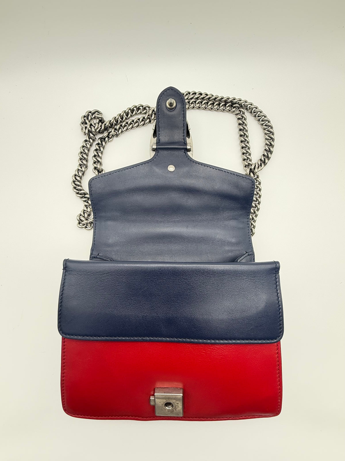 The bag open, showing the navy flap and red front panel